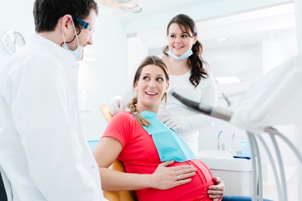 mulher grávida no dentista conversando com ele
