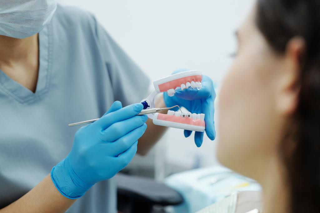 dentista mostrando molde para paciente enquanto explica algo