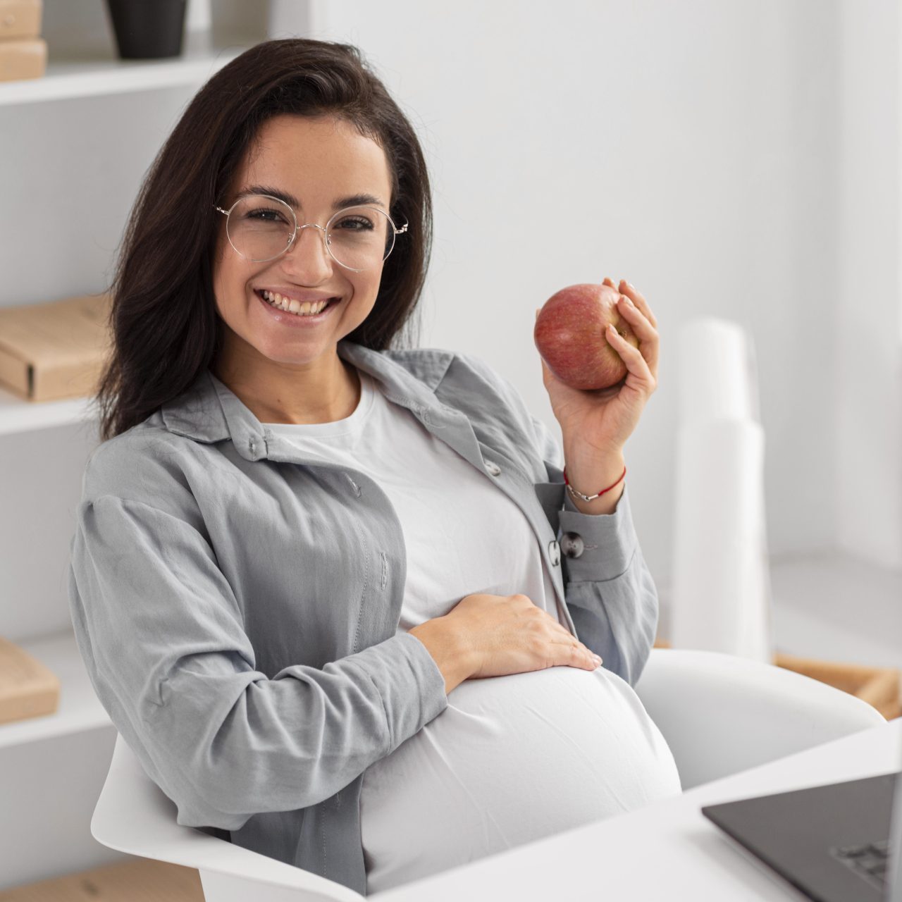 mulher grávida segurando uma maçã
