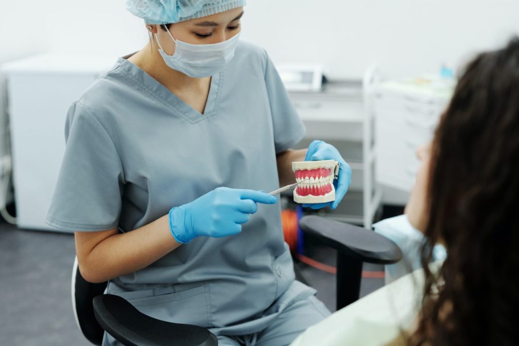 dentista com molde de boca mostrando algo para paciente