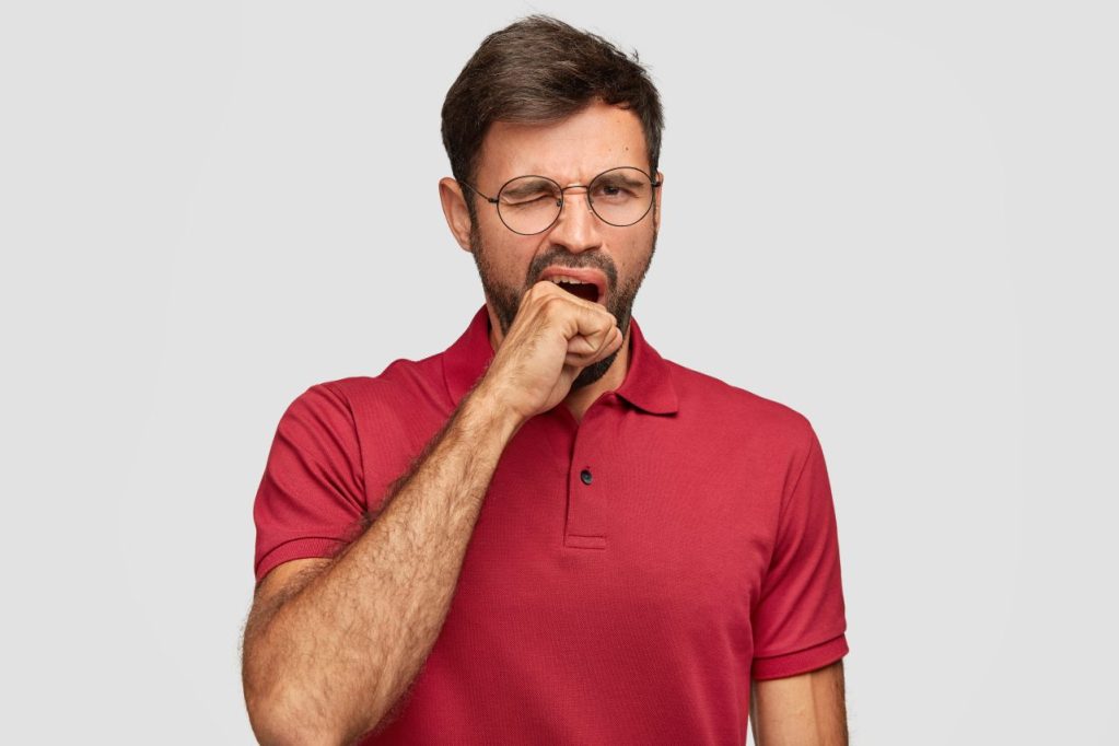 homem de camiseta vermelha bocejando 