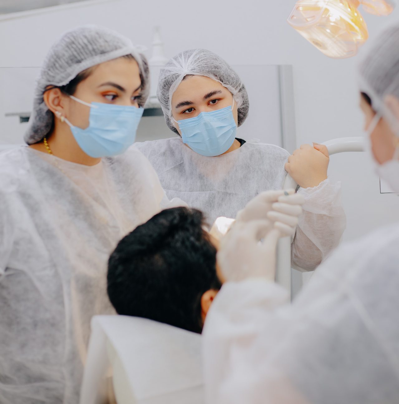 Alunas da Pós-Graduação da EAP Goiás assistindo procedimento em paciente. 