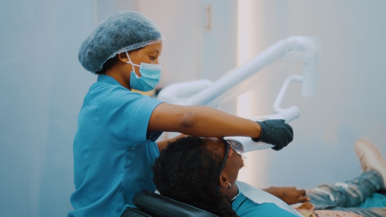 dentista mulher usando epis atendendo paciente