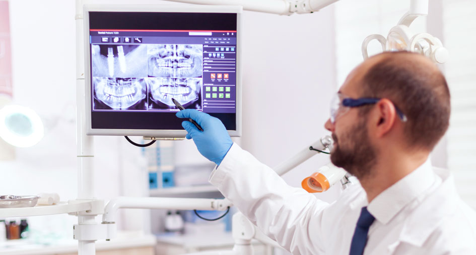 Dentista apontando panorâmicas na tela