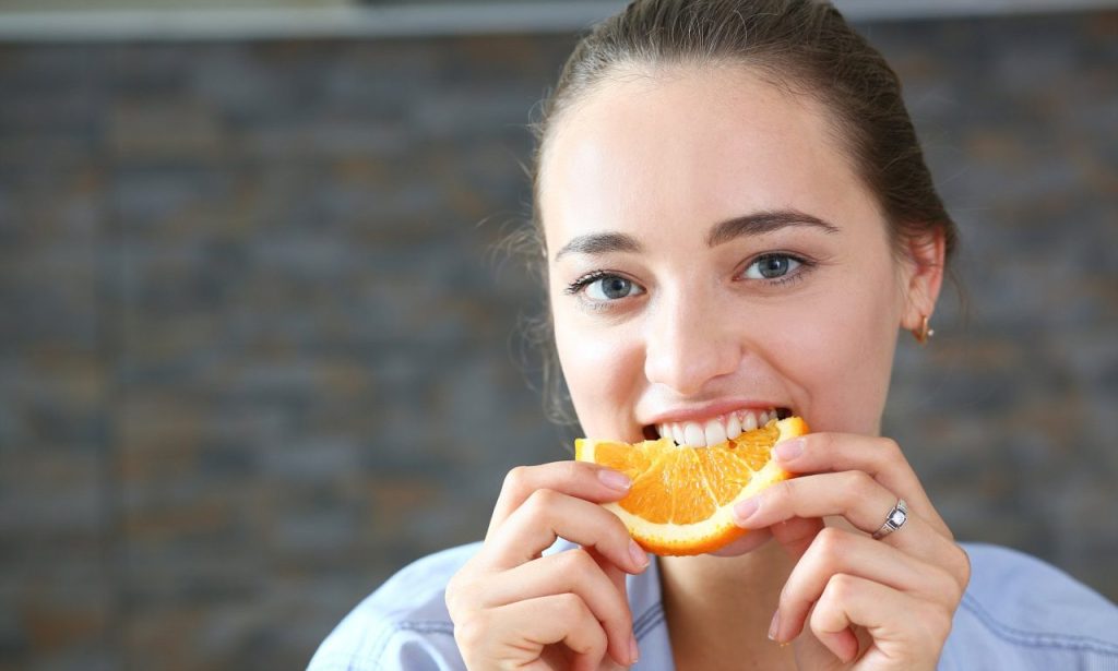 mulher comendo laranja