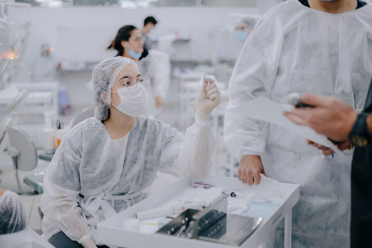 Imagem da EAP Goiás com aluna sentada na clínica segurando algo na mão