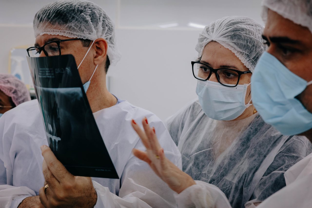 três dentistas conversando e analisando raio-x