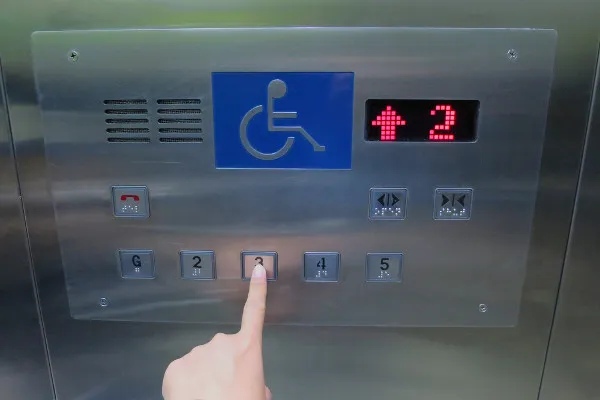 elevador com símbolo de pcd e escrita em braille