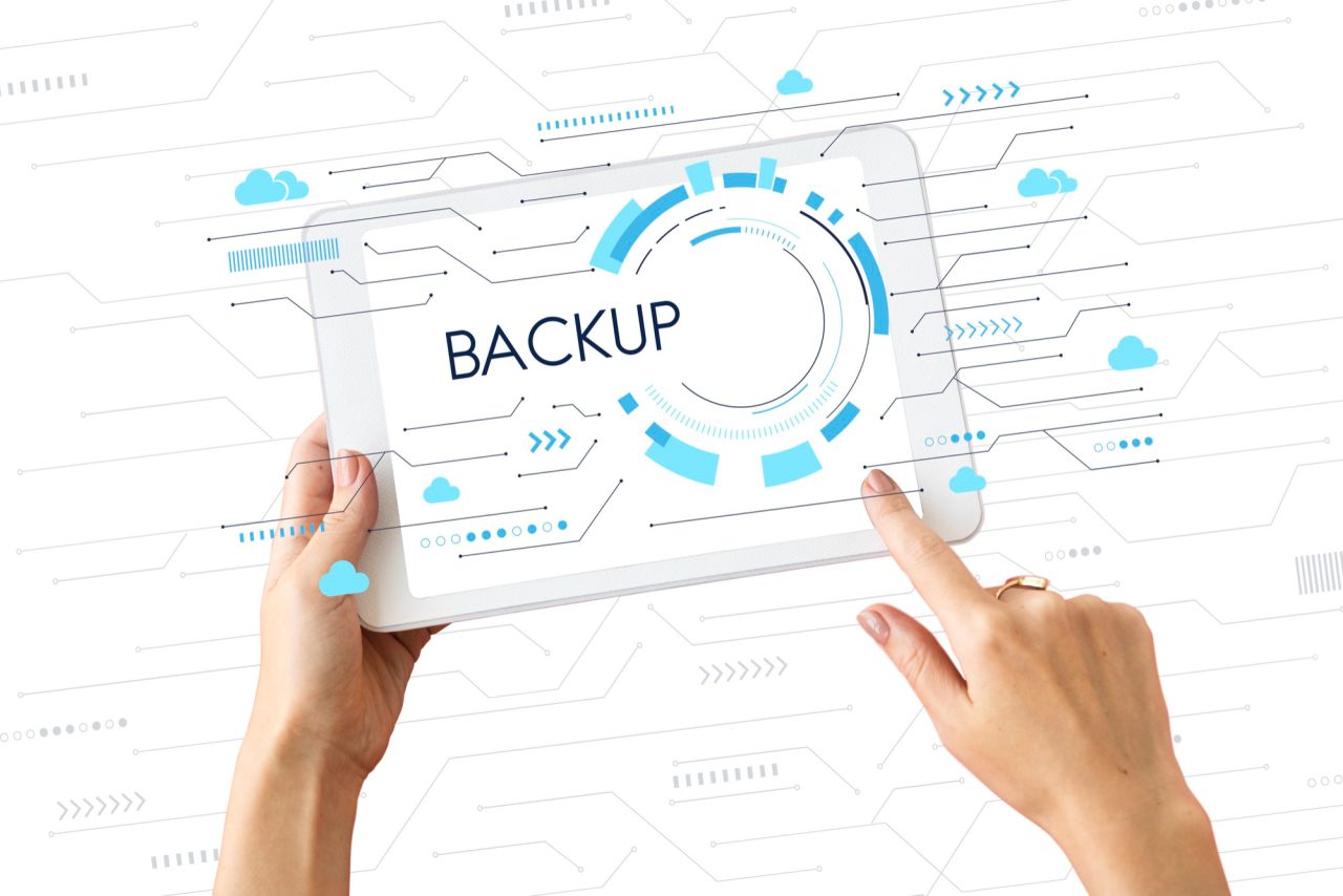 Tablet escrito "backup" e pessoa clicando na tela