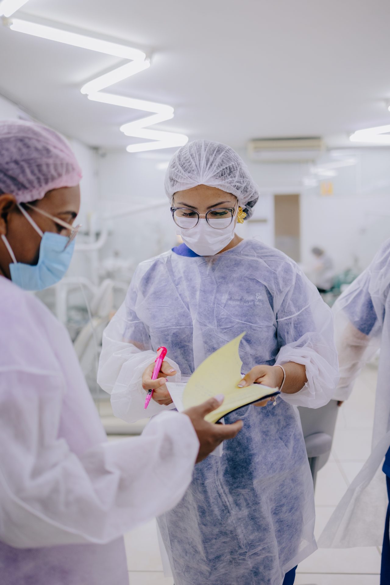 Duas dentistas da EAP olhando prontuário e segurando caneta na mão