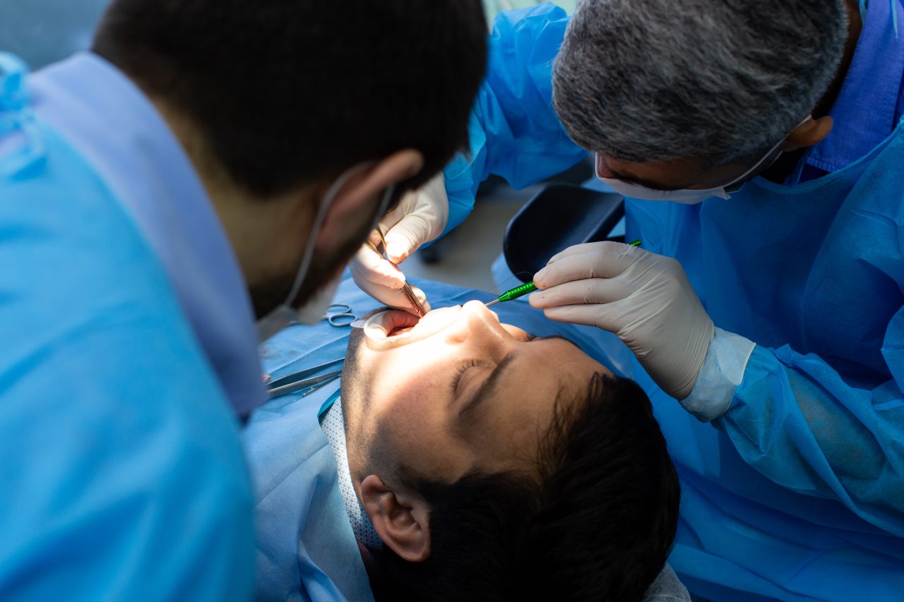 dois dentistas fazendo tratamento em paciente