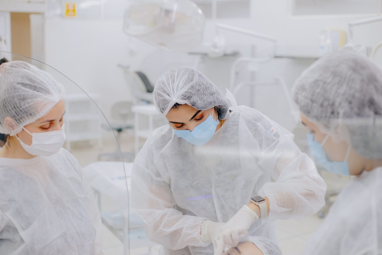 três dentistas mulheres tratando paciente