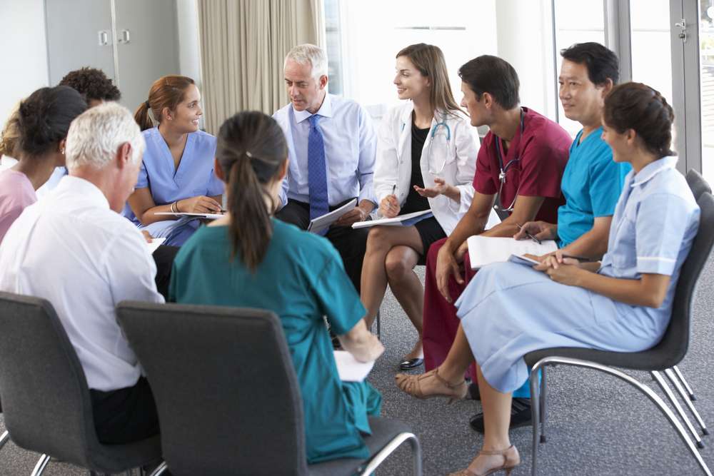 médicos sentados em círculos em cadeiras conversando