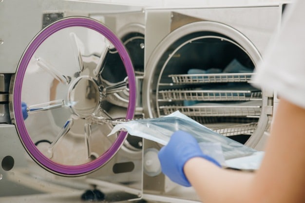 colocando envelopes para esterilização dentro de autoclave
