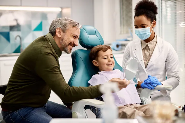 dentista com pai e filho no consultório