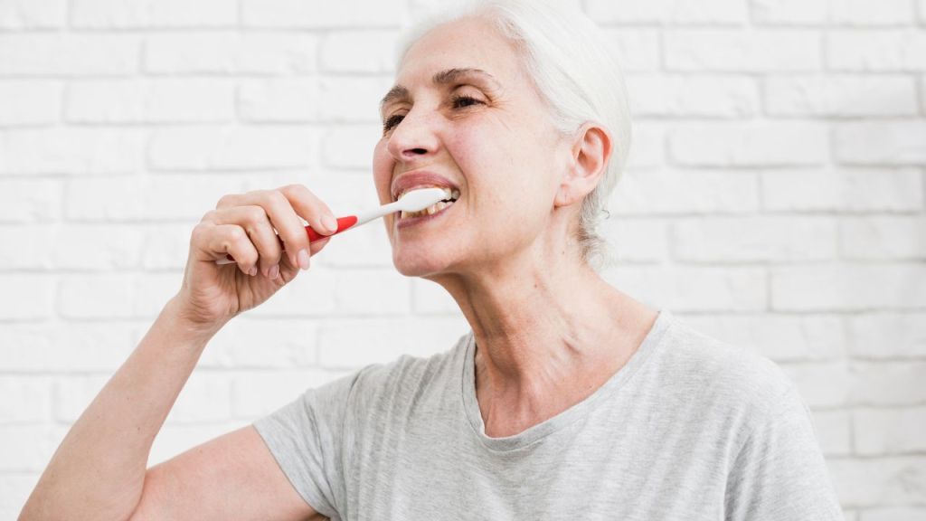senhora escovando os dentes