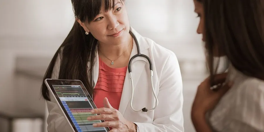 Doutora mostrando pesquisa para paciente em seu tablet