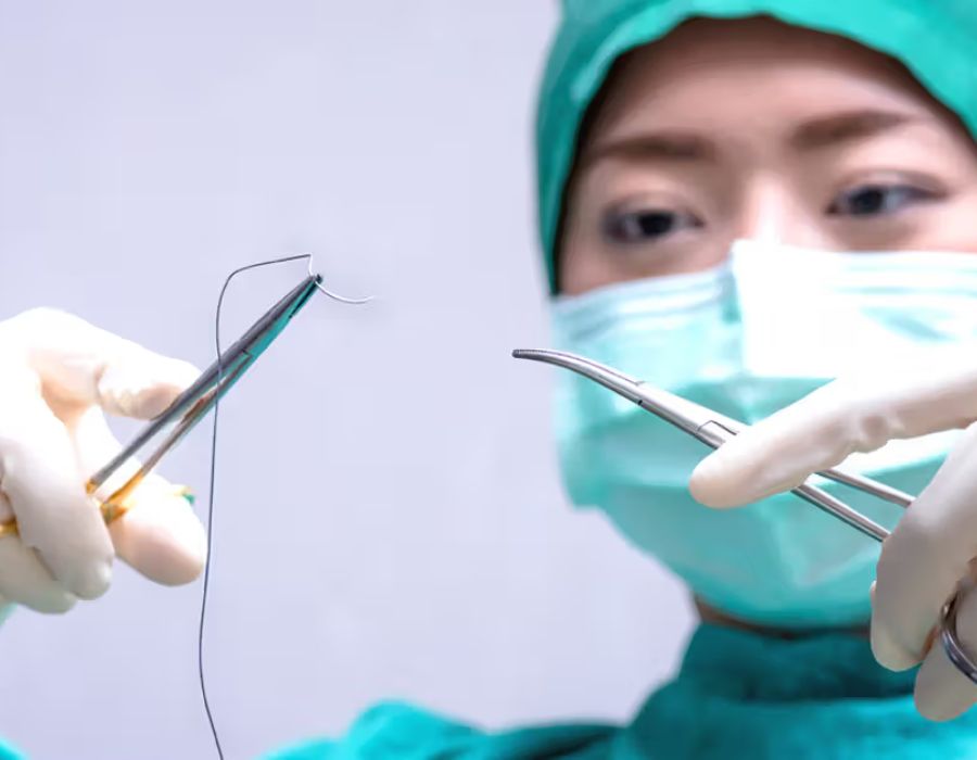 Dentista segurando fio de sutura e tesoura