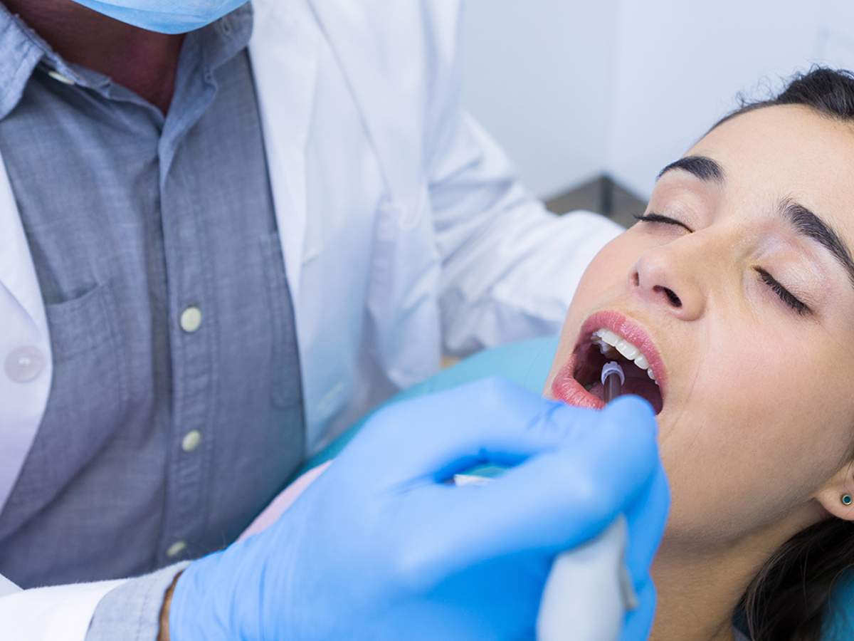 mulher paciente no dentista recebendo tratamento dentário