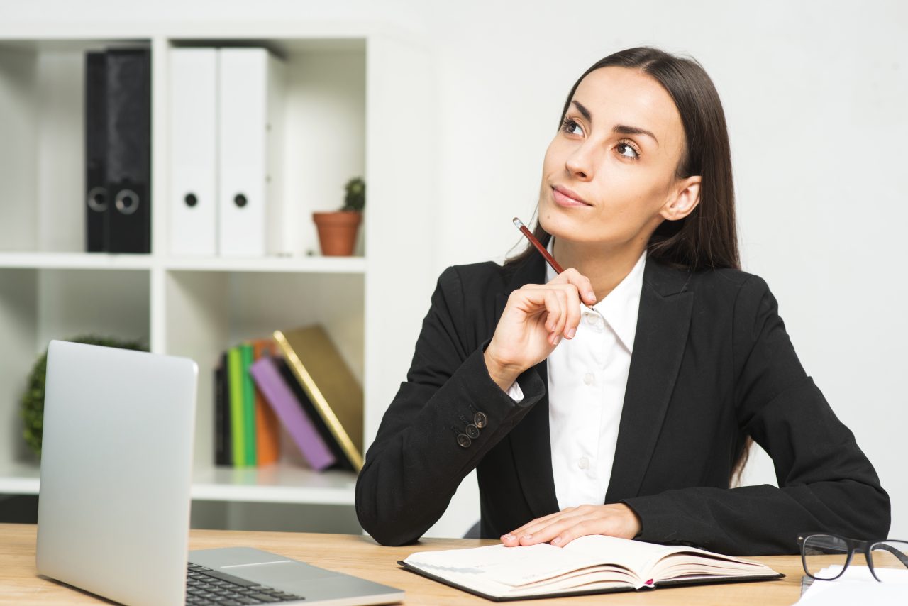 Mulher sentada em escritória pensando
