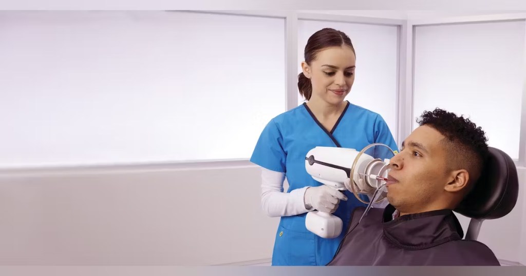 Dentista tirando raio-x da boca do paciente, com um raio-x portátil