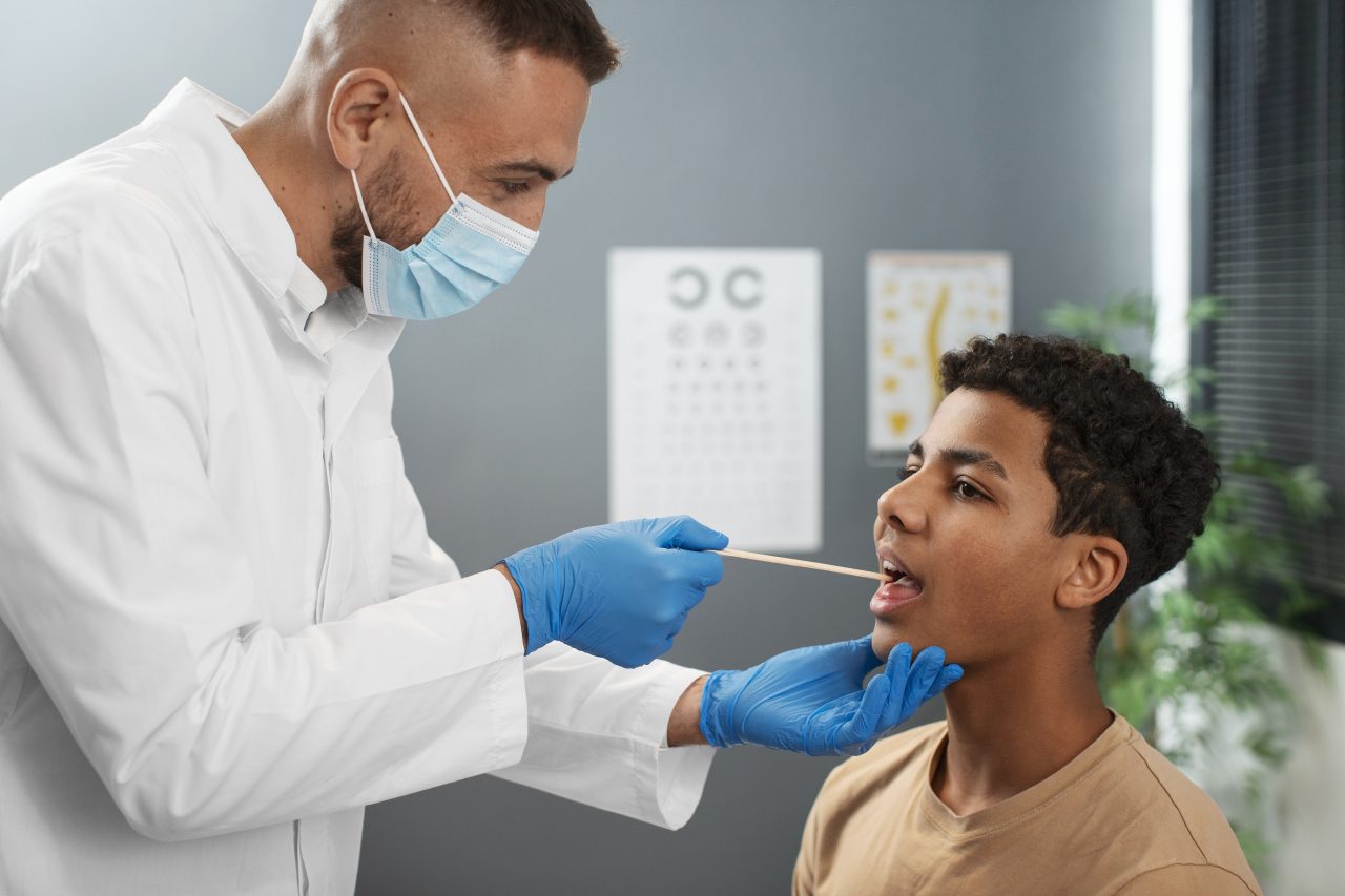 Dentista conferindo boca de paciente adolescente