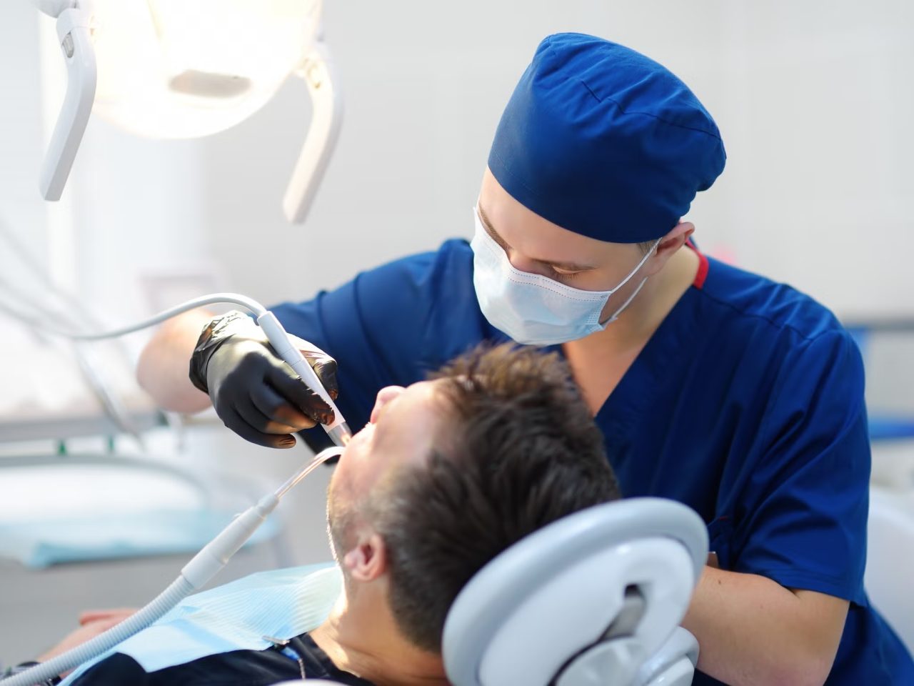 Dentista realizando tratamento em dentes de paciente