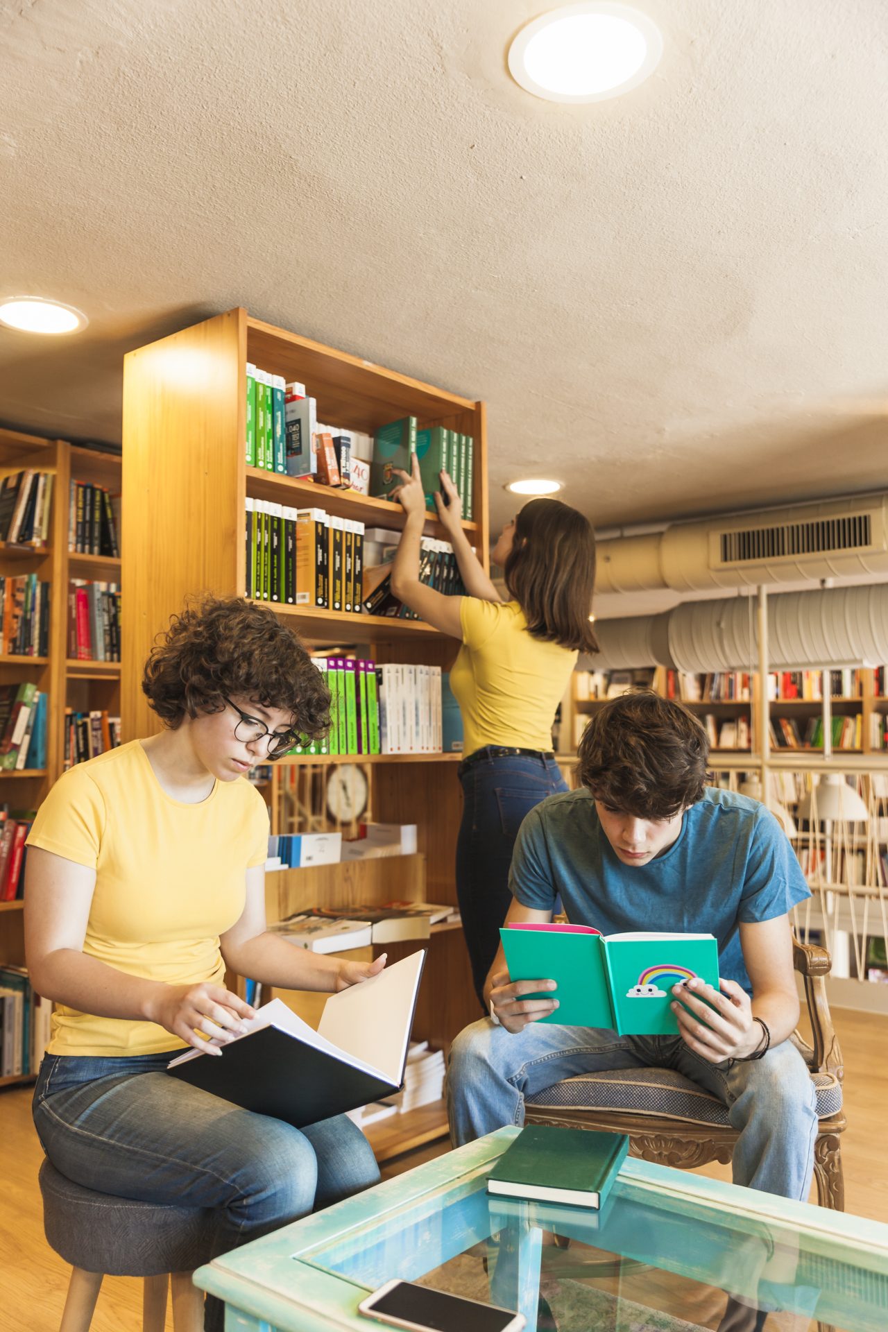 jovens em biblioteca lendo livros