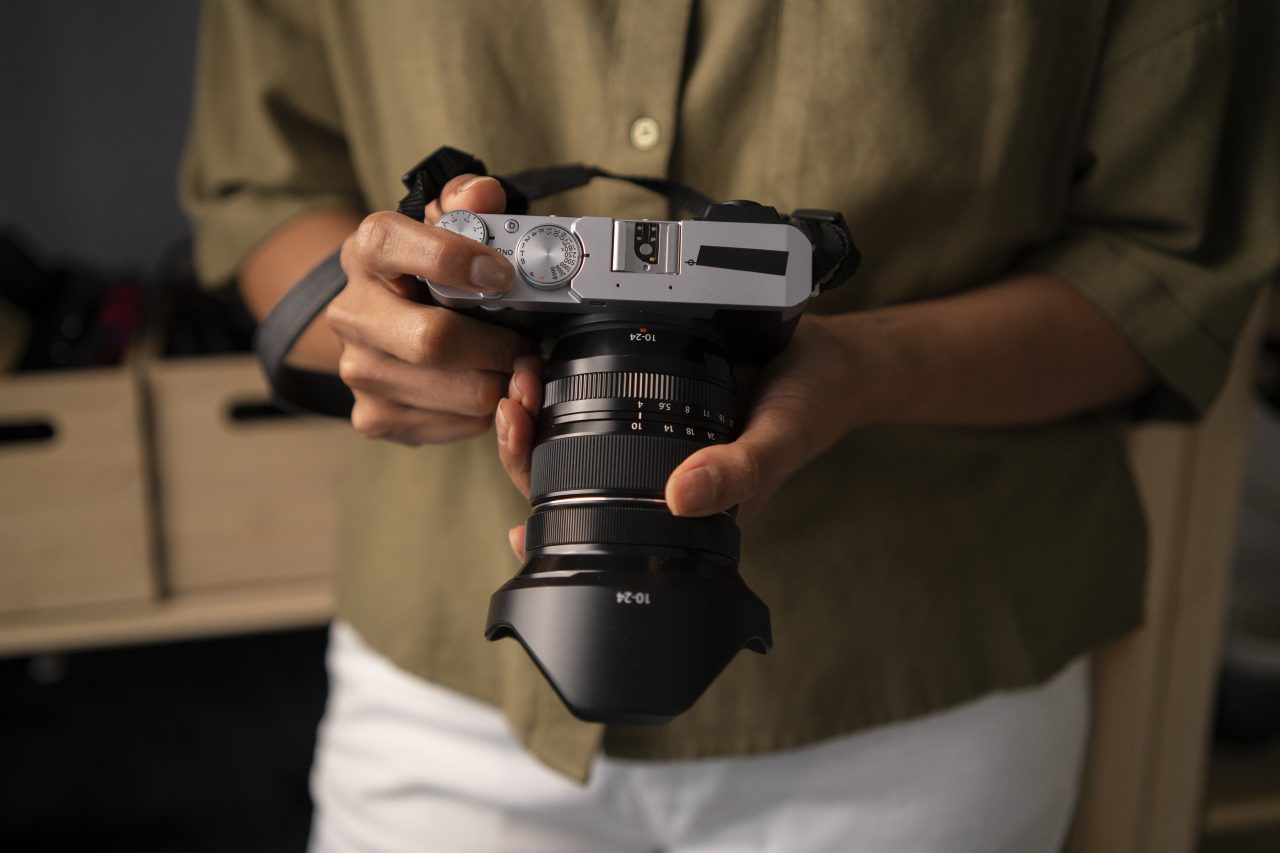 Fotógrafo ajustando algo em câmera profissional.