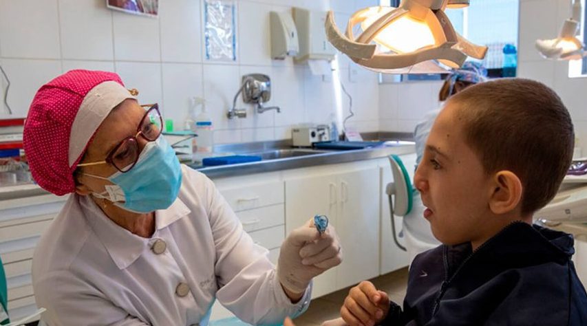 Dentista fazendo avaliação de criança com lábio leporino