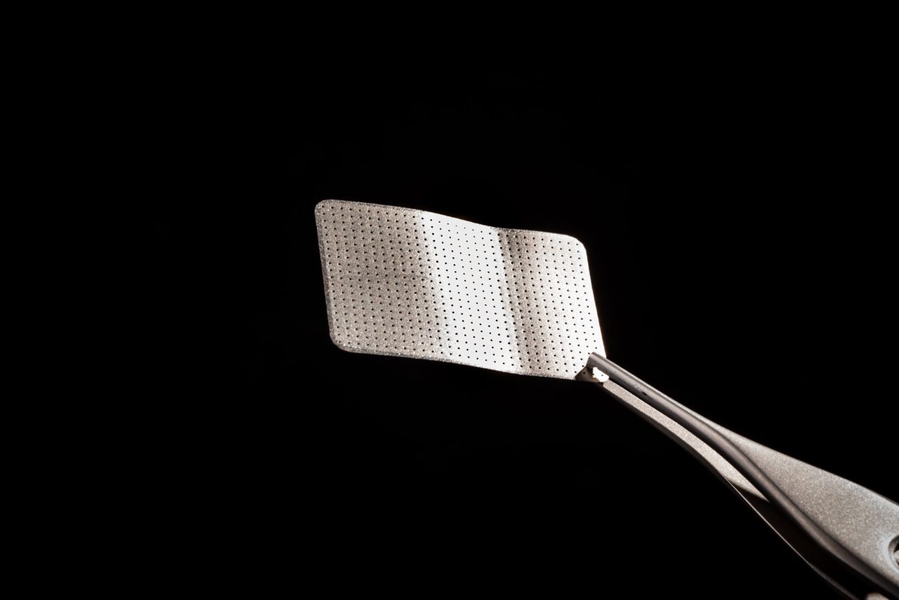 Biomaterial metálico (é uma pequena placa retangular de metal)