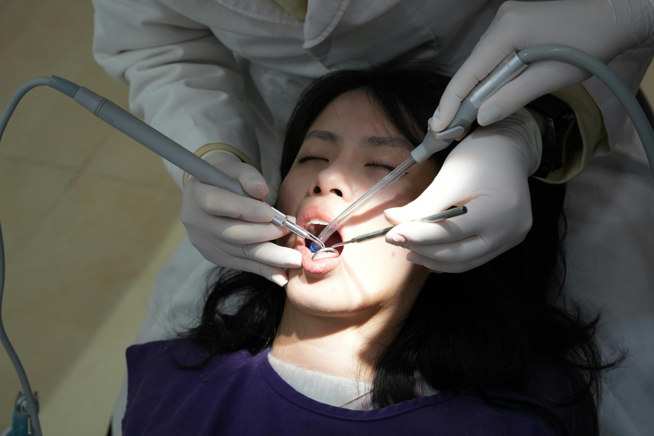 Dentista realizando limpeza em paciente