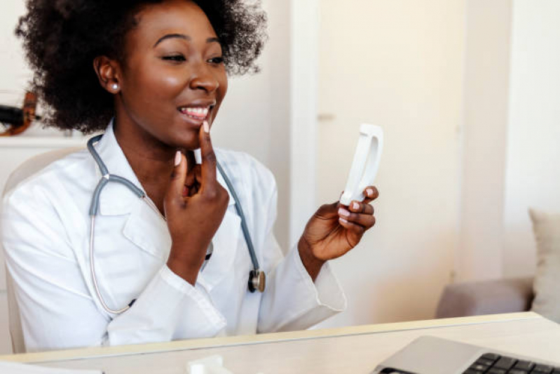 Fonoaudióloga está em seu consultório mostrando para paciente como pronunciar palavra corretamente, ela aponta para a própria boca.