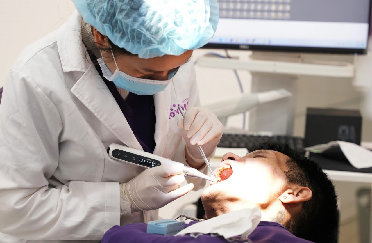Dentista está realizando restauração em dente de paciente.