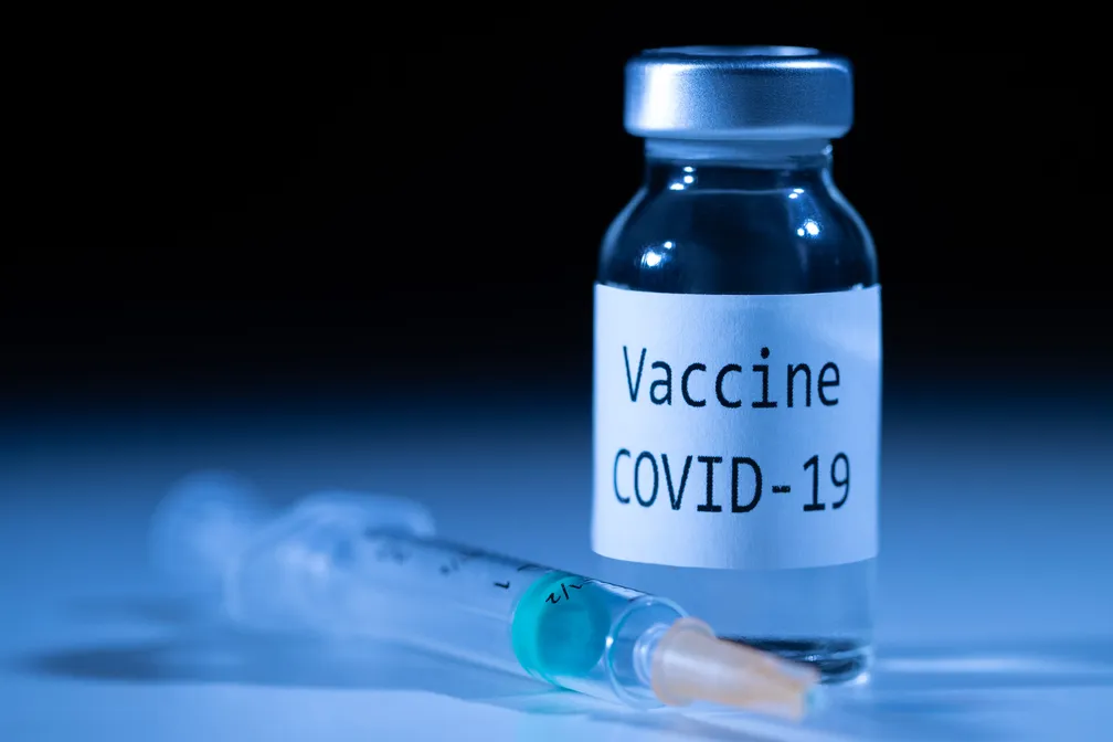 frasco da Vacina contra Covid-19 e seringa deitada ao lado