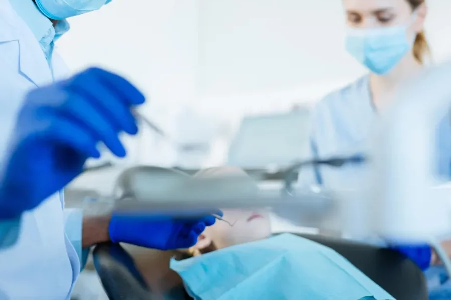 Dentista e sua assistente atendendo criança.
