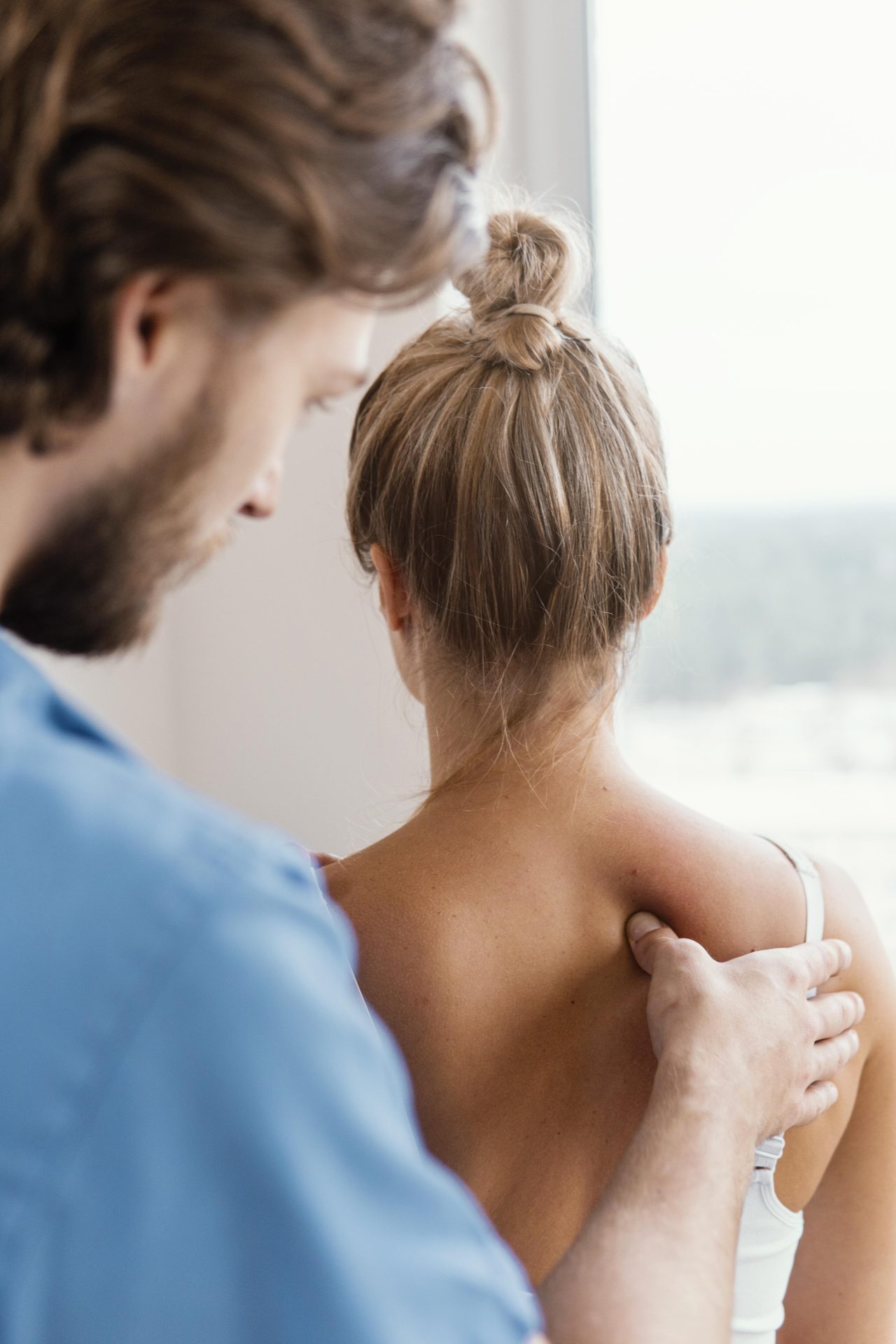Profissional massageando costas de mulher.