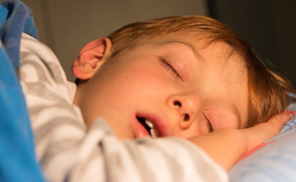 Menino dormindo de boca aberta;