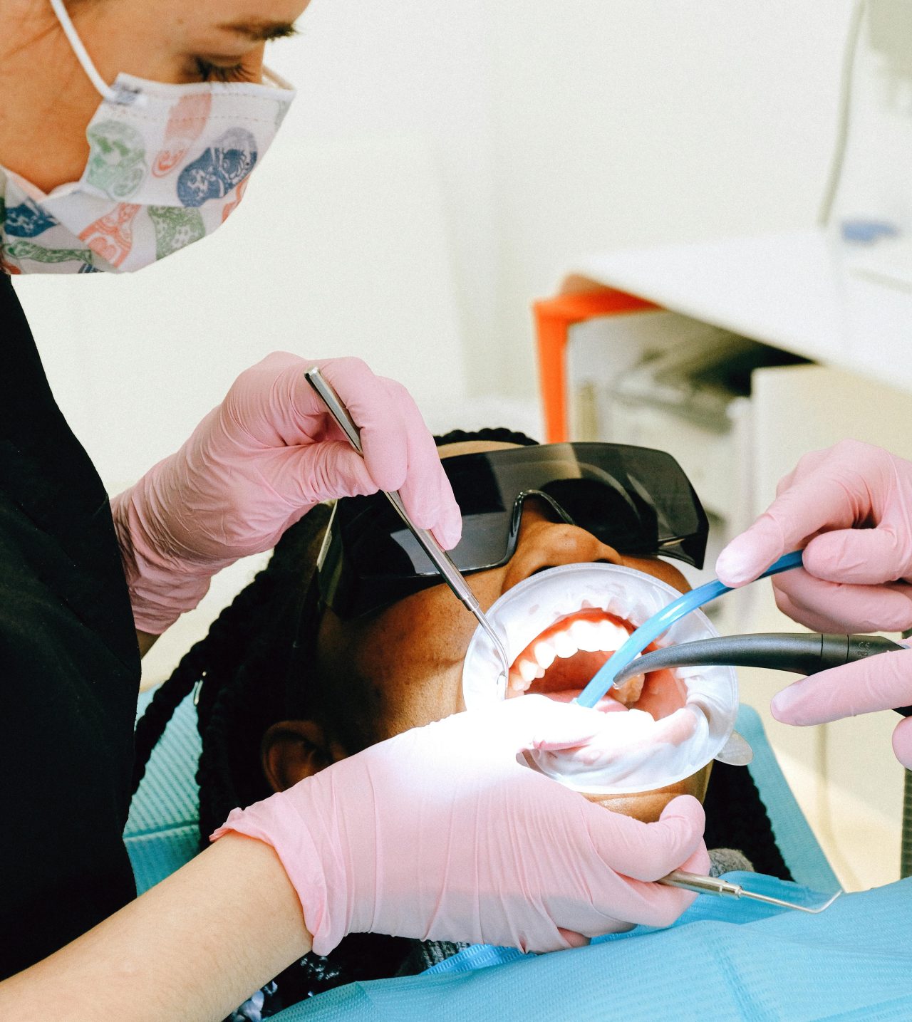Dentista e assistente realizando tratamento em paciente.