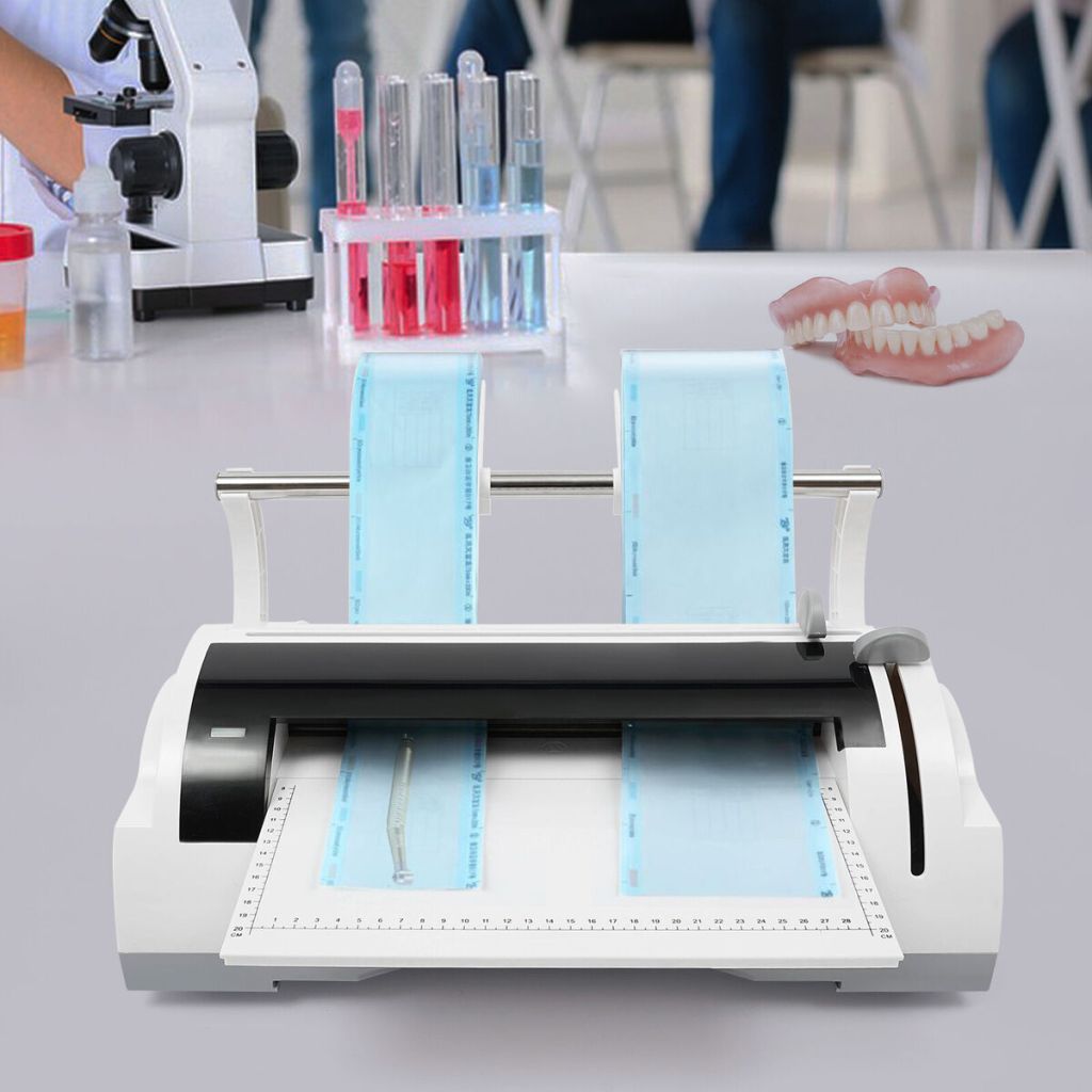 Seladora odontológica em laboratório. Ao fundo tem molde dentário e tubos.