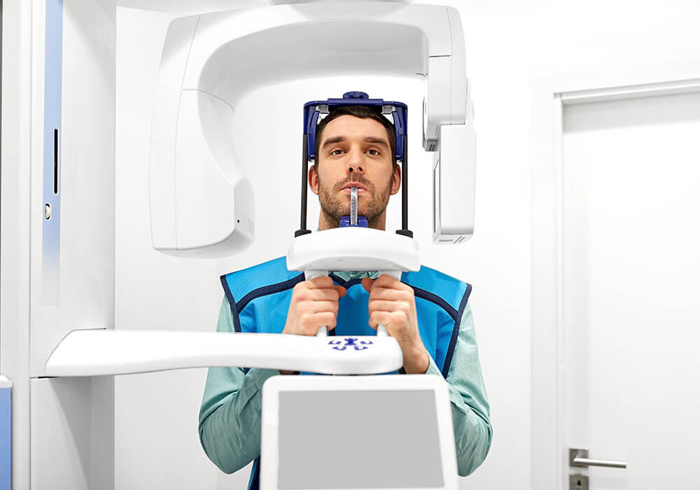 Paciente posicionado em máquina de panorâmica.