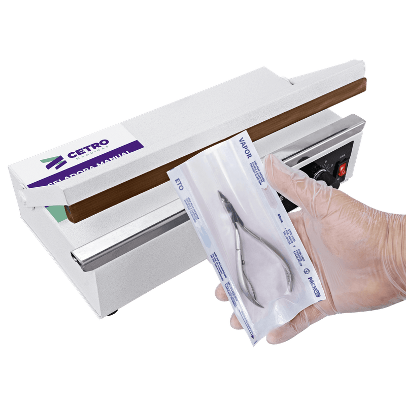 Pessoa segurando um alicate embalado por uma seladora odontológica manual