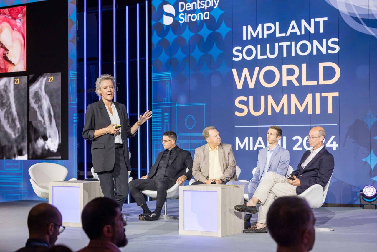 Apresentadores no palco do Implant Solutions World Summit 2024