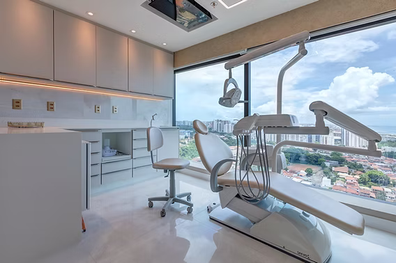 Consultório odontológico todo branco com vista para a cidade.