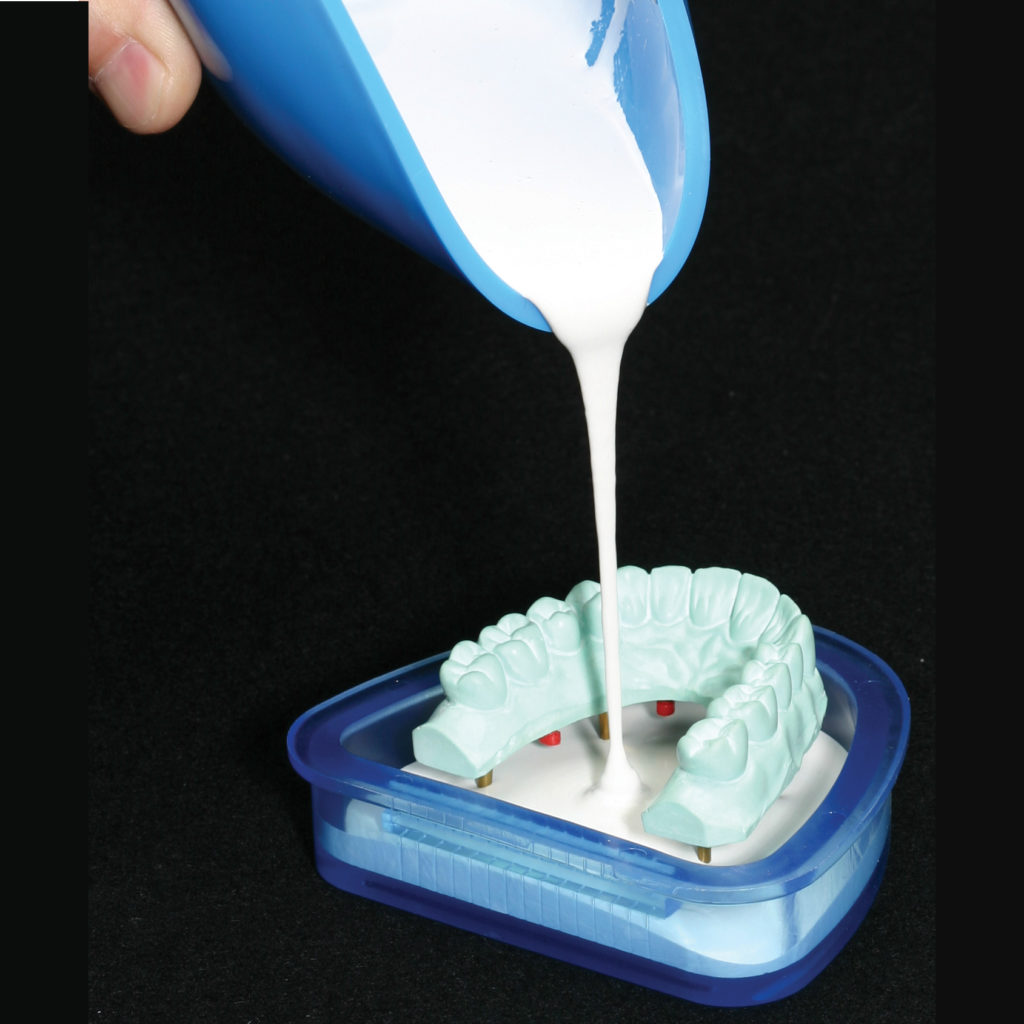 Derramando gesso em molde de dentes.