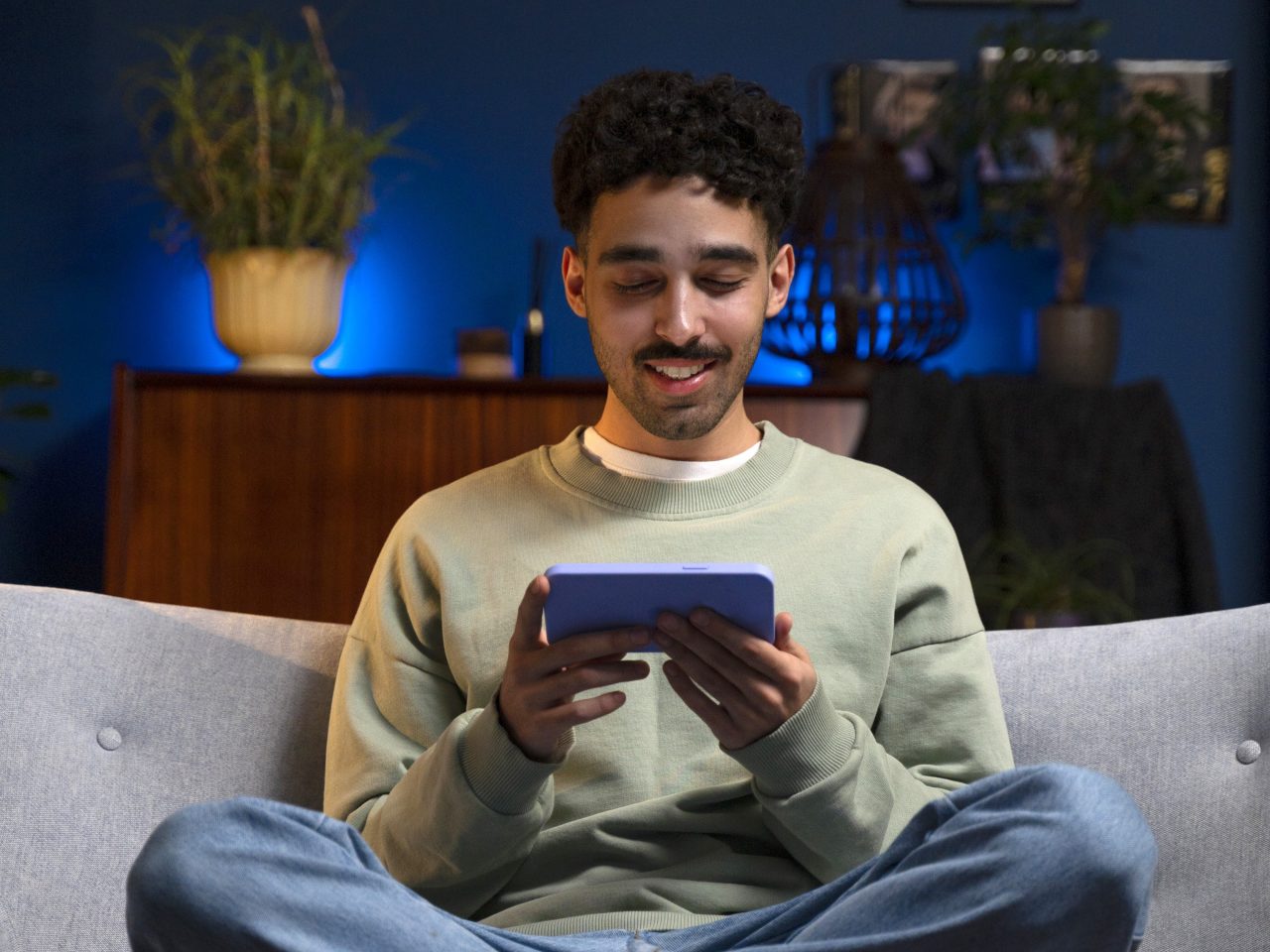 Homem está vendo vídeos no celular.