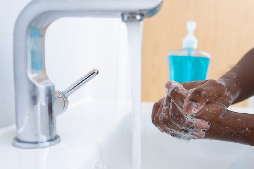 Lavando as mãos na pia.