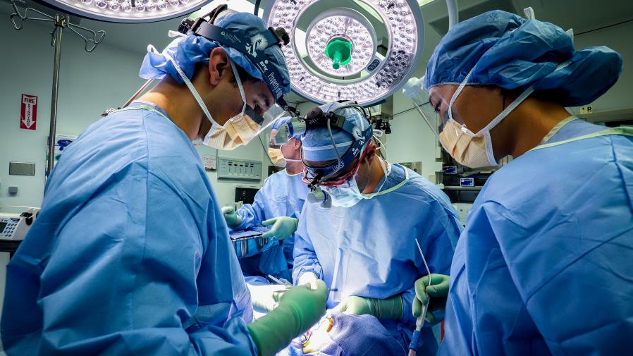 Dentistas realizando cirurgia bucal.