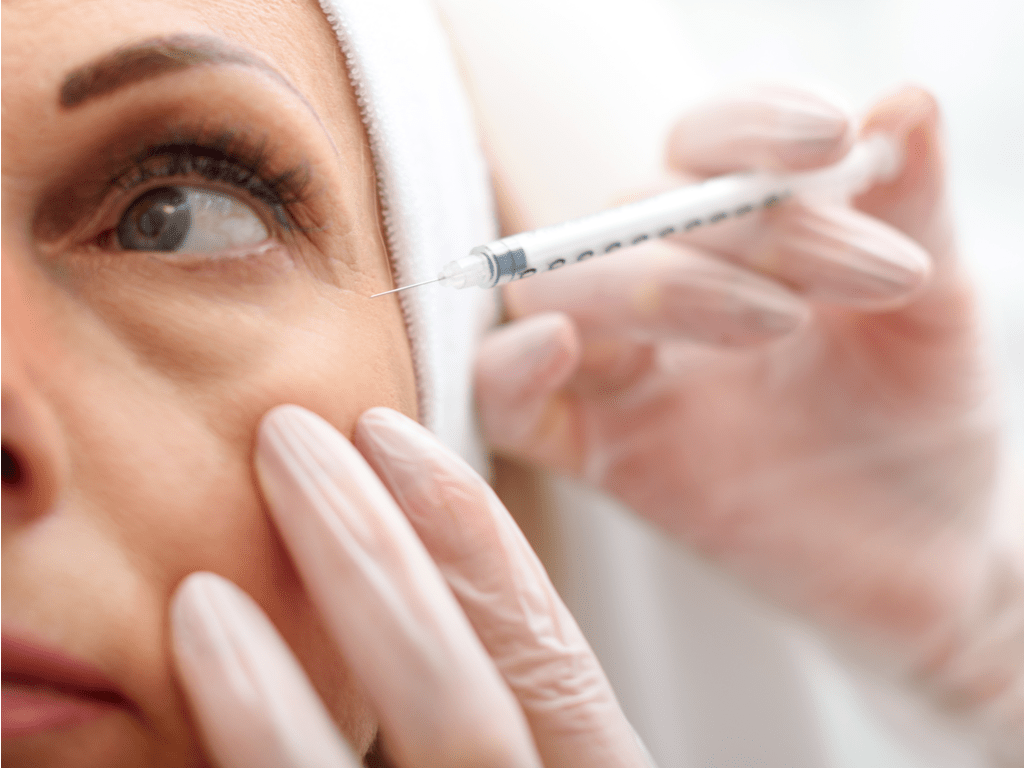 Aplicando hialurose na olheira da paciente.