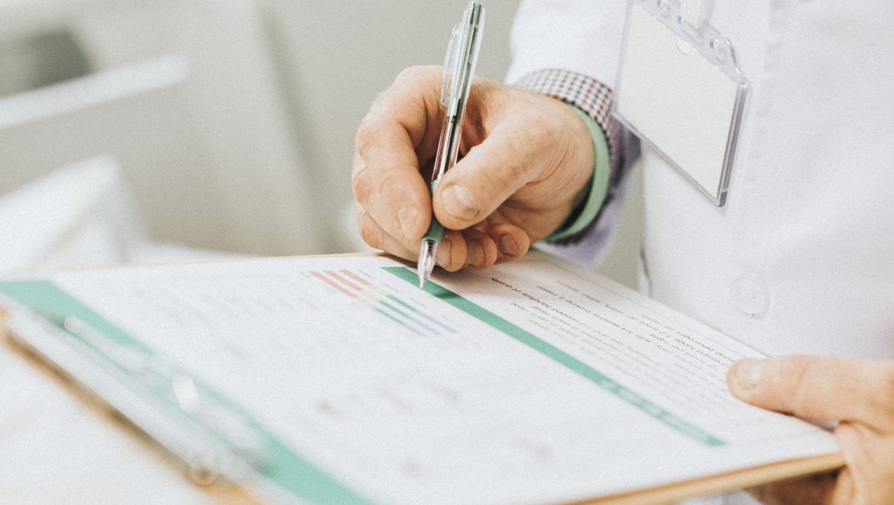 médico preenchendo folha